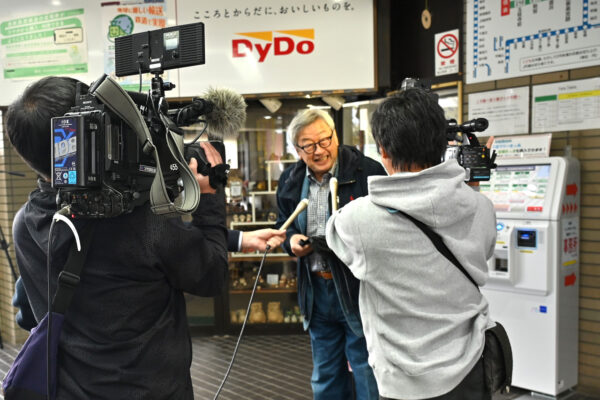 報道陣のインタビューに応える、最初に購入した地元在住の小河さん